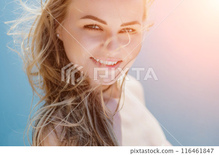 Portrait of a blond woman at the sea, a woman makes photos for memory from a trip to the sea to show to friends. Portrait of a blond woman at the sea, a woman makes photos for memory from a trip to the sea to show to friends. 116461847