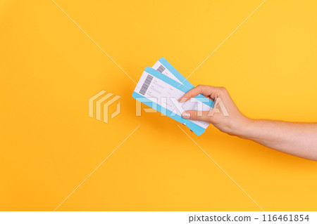 Hand holding tickets against yellow background 116461854