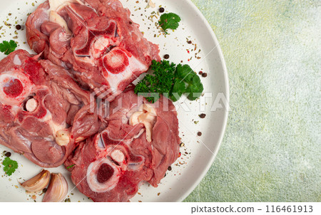 raw steak, calf's neck on the bone, fresh meat, on a white plate, top view, no people, 116461913