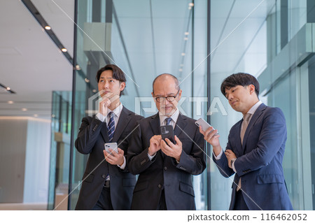 Male businessman thinking while typing on smartphone Male businessman thinking while typing on smartphone 116462052