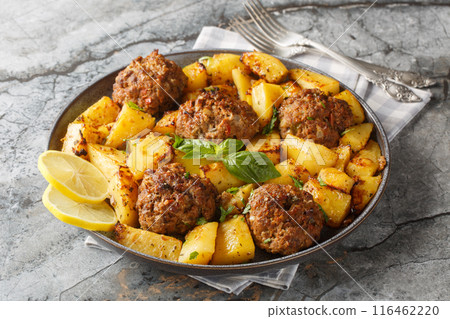 Greek baked bifteki beef patties with lemon potatoes closeup on the plate. Horizontal Greek baked bifteki beef patties with lemon potatoes closeup on the plate. Horizontal 116462220