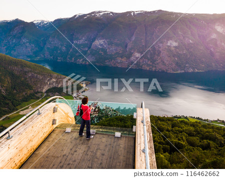 Tourist enjoying fjord view on Stegastein viewpoint Norway Tourist enjoying fjord view on Stegastein viewpoint Norway 116462662