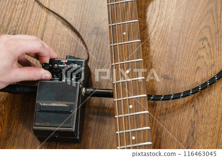 Man adjusting guitar effects pedal Man adjusting guitar effects pedal 116463045
