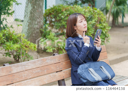 High school girls using smartphones in the park 116464138