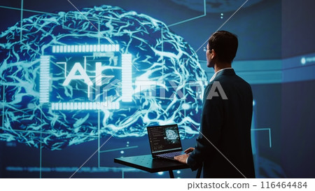 AI system administrator using laptop device in high tech futuristic workspace. Man working on notebook to automatize tasks using artificial intelligence technology, camera B 116464484