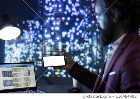 Influential board member holds phone with blank screen layout, managing financial resources and company income. Chairman examines global trends, uses white display on smartphone. Influential board member holds phone with blank screen layout, managing financial resources and company income. Chairman examines global trends, uses white display on smartphone. 116464498