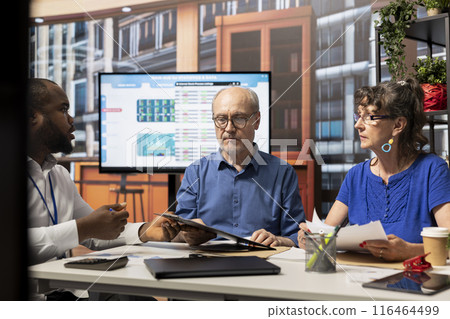 Elderly people exploring pension plans with a financial expert, focusing on long term financial stability and investment strategy. Clients consulting broker about their retirement options. 116464499