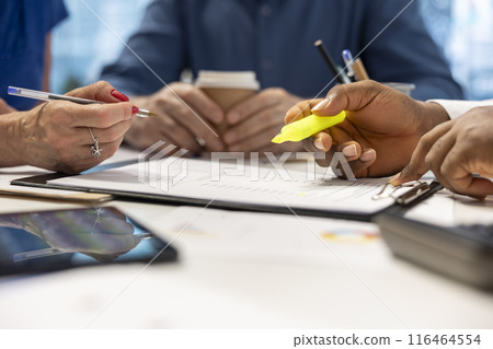 Financial advisor expert highlighting important terms on retirement plan contract, discussing finances and investments to secure life savings. Broker assisting mature couple. Close up. 116464554