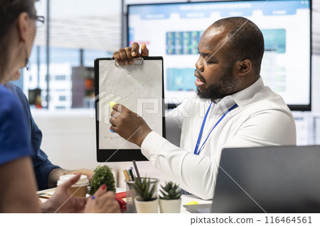 Insurance broker explaining financial plans to senior couple in a modern office, receiving expert advice on retirement plans. Discussing investment strategy, pension options and savings. Insurance broker explaining financial plans to senior couple in a modern office, receiving expert advice on retirement plans. Discussing investment strategy, pension options and savings. 116464561