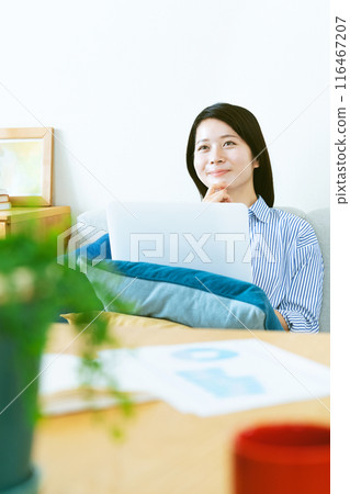 A woman who plays a personal computer in the living room 116467207
