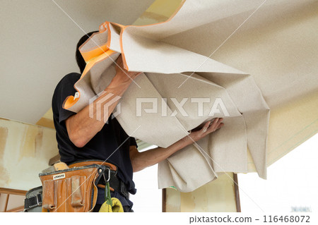 A craftsman laying wallpaper during the renovation of a used house A craftsman laying wallpaper during the renovation of a used house 116468072
