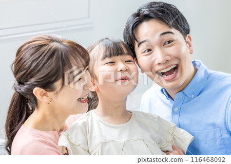 Smiling young family relaxing in the living room 116468092