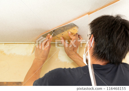 A craftsman laying wallpaper during the renovation of a used house A craftsman laying wallpaper during the renovation of a used house 116468155