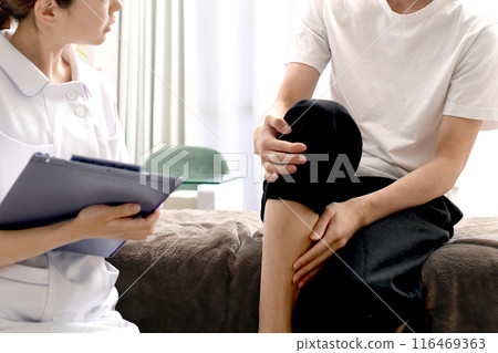 A female doctor interviewing a male patient suffering from leg pain 116469363