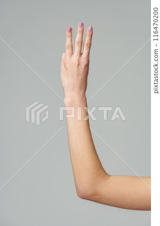 Female hand gesturing numbers on gray background Female hand gesturing numbers on gray background 116470200