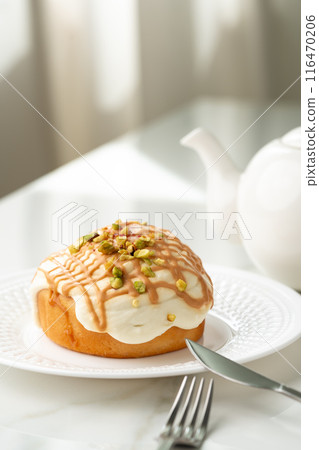Cinnamon roll bun with icing on plate 116470206