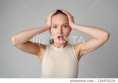 Startled Woman With Surprised Expression on gray background Startled Woman With Surprised Expression on gray background 116470229