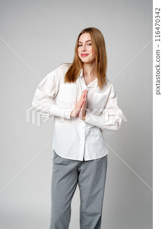 Joyful Young Blonde Woman Smiling against gray background Joyful Young Blonde Woman Smiling against gray background 116470342