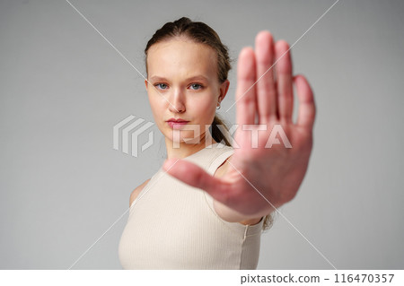 Young Woman Making Stop Sign With Hands on gray background Young Woman Making Stop Sign With Hands on gray background 116470357