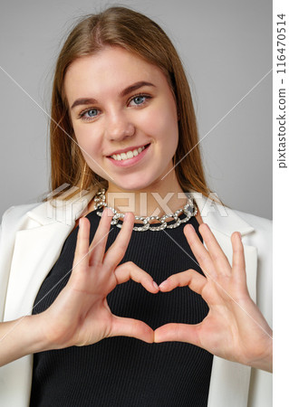 Woman Making Heart With Hands on gray background 116470514