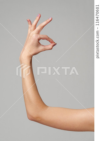 Female hand showing OK sign on gray background Female hand showing OK sign on gray background 116470681