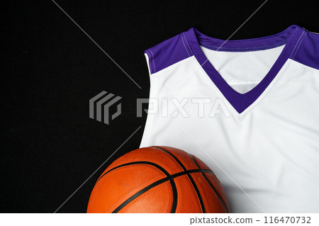 Close-Up of Basketball and White and Purple Jersey on a Black Background Close-Up of Basketball and White and Purple Jersey on a Black Background 116470732
