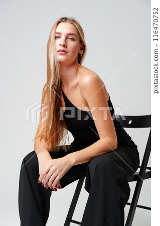 Young Woman Sitting on Chair Posing for Picture 116470752