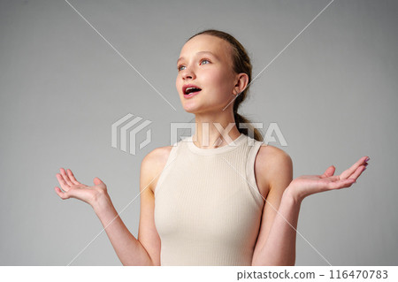 Startled Woman With Surprised Expression on gray background 116470783
