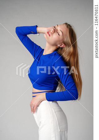 Young Woman model in Blue Top and White Pants posing on white background Young Woman model in Blue Top and White Pants posing on white background 116470811
