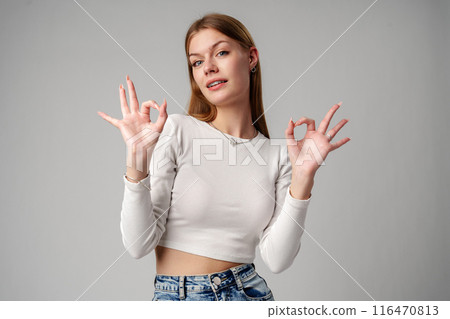 Young Woman Giving Thumbs Up Sign in studio Young Woman Giving Thumbs Up Sign in studio 116470813