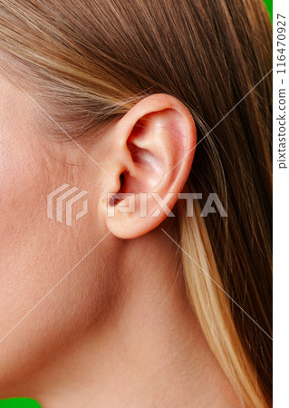Womans Ear Close Up With Green Background Womans Ear Close Up With Green Background 116470927
