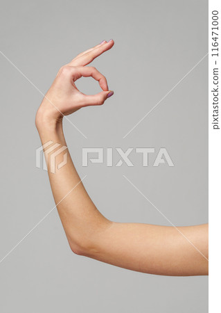 Female hand showing OK sign on gray background Female hand showing OK sign on gray background 116471000