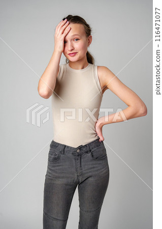 Young Woman Covering Face With Hand on gray background Young Woman Covering Face With Hand on gray background 116471077