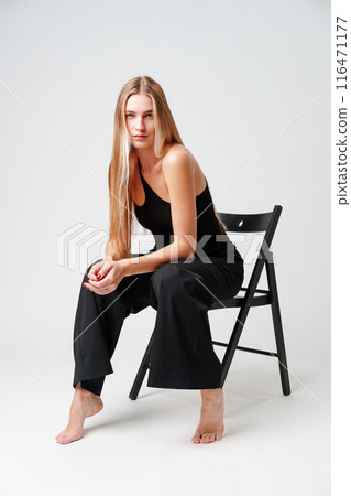 Young Woman Sitting on Chair Posing for Picture 116471177