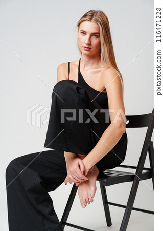 Young Woman Sitting on Chair Posing for Picture 116471228