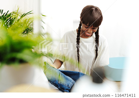 African Woman Folding Laundry After Washing Clothes in Modern Laundry Room African Woman Folding Laundry After Washing Clothes in Modern Laundry Room 116471411