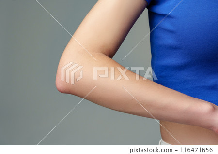 Closeup of a beautiful woman elbow on gray background Closeup of a beautiful woman elbow on gray background 116471656