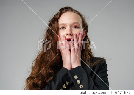 Startled Woman With Surprised Expression on gray background 116471682
