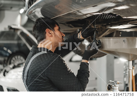 Car mechanic changing oil in a car service Car mechanic changing oil in a car service 116471758