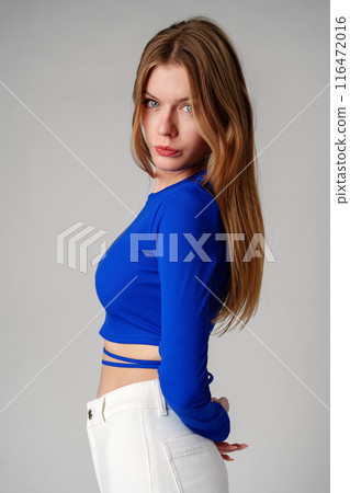 Young Woman model in Blue Top and White Pants posing on white background 116472016