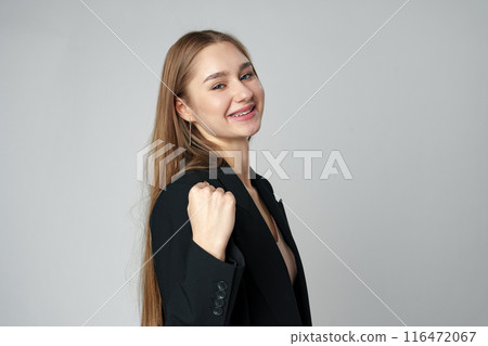 Young woman standing with her arms lifted high above her head expressing joy and triumph 116472067