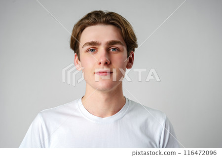 Young Man in White Shirt Looking at Camera 116472096