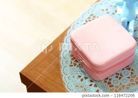 Elegant Pink Jewelry Box on a Lace Doily and Wooden Surface in Soft Daylight Elegant Pink Jewelry Box on a Lace Doily and Wooden Surface in Soft Daylight 116472206