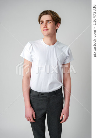 Young Man in a White T-Shirt and Grey Trousers Looking to His Right Young Man in a White T-Shirt and Grey Trousers Looking to His Right 116472336