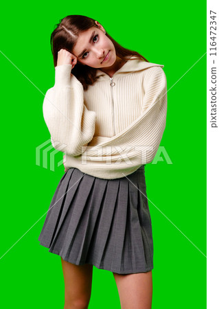 Young Woman Looking Bored and Disinterested Against Green Background Young Woman Looking Bored and Disinterested Against Green Background 116472347