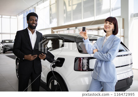 Dealer sells electric SUV to business woman at car dealership 116472995