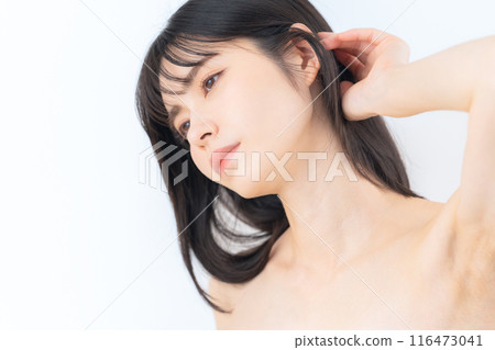 A middle-aged woman doing skin care against a white background 116473041