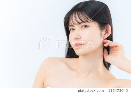 A middle-aged woman doing skin care against a white background A middle-aged woman doing skin care against a white background 116473043