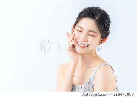 A middle-aged woman doing skin care against a white background 116473067