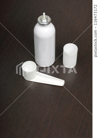 Inhaler for the treatment of respiratory organs. Spray can and cap white. On a dark surface. Inhaler for the treatment of respiratory organs. Spray can and cap white. On a dark surface. 116473172